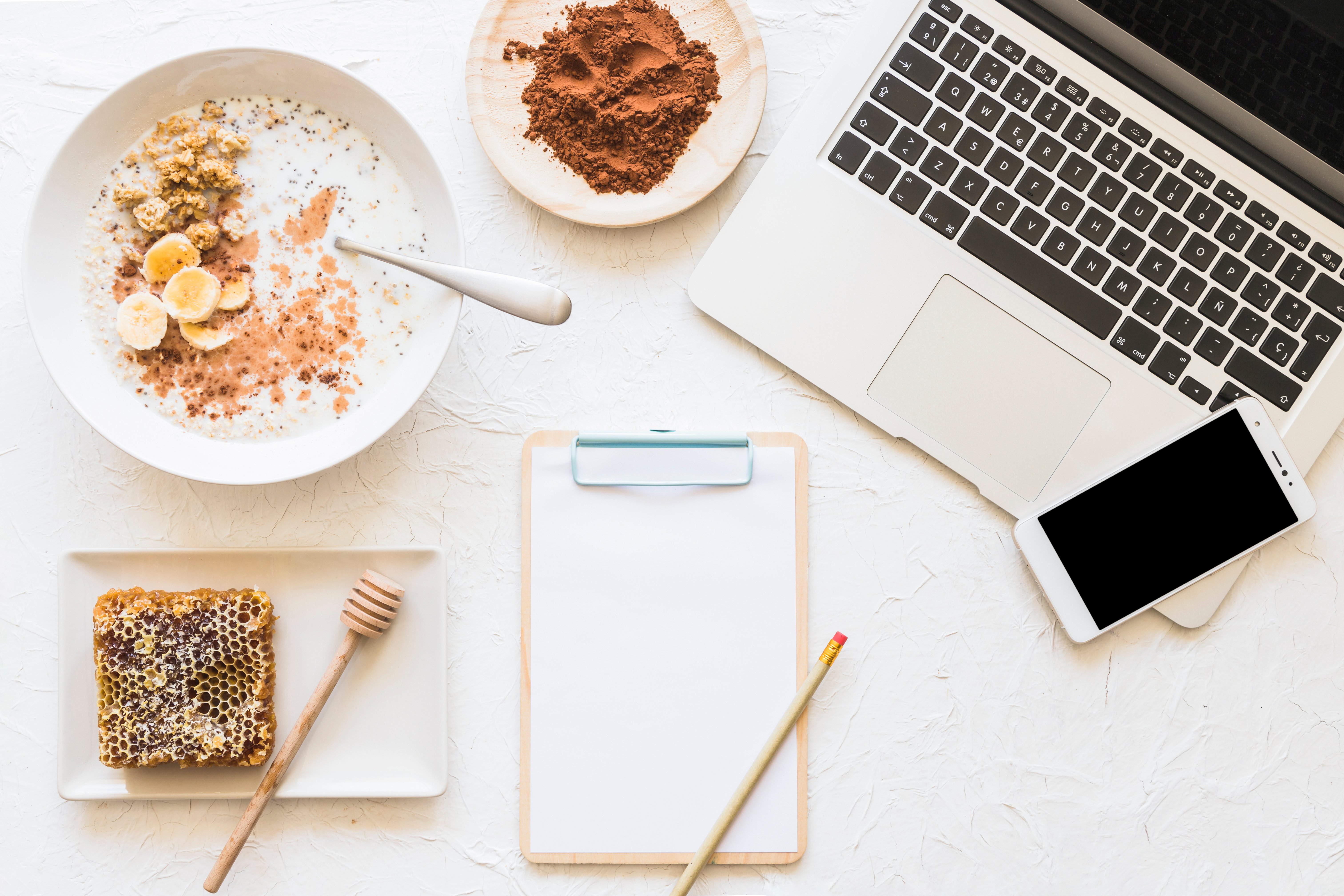 Soaked oatmeal and honeycomb with laptop and cellphone on workplace